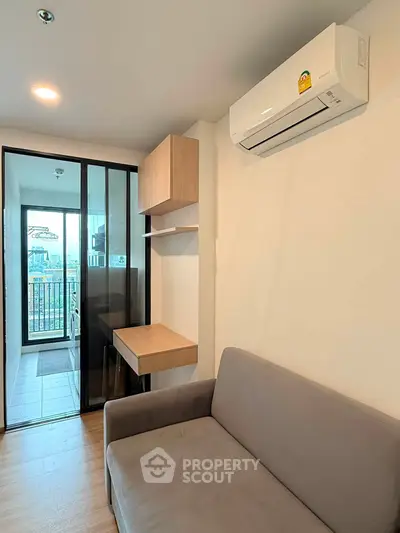 Modern living room with air conditioning and balcony view in a stylish apartment.