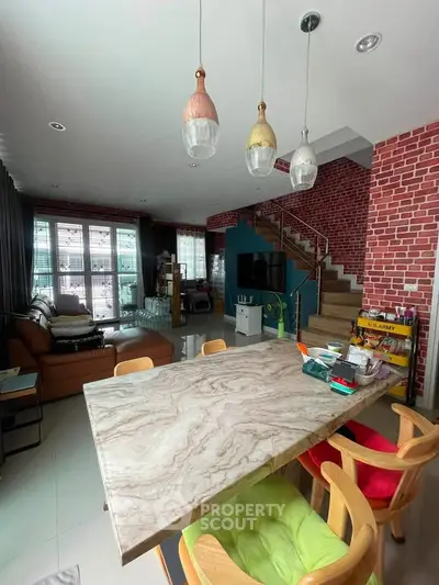 Stylish living room with modern decor and open layout, featuring a marble dining table and cozy seating area.