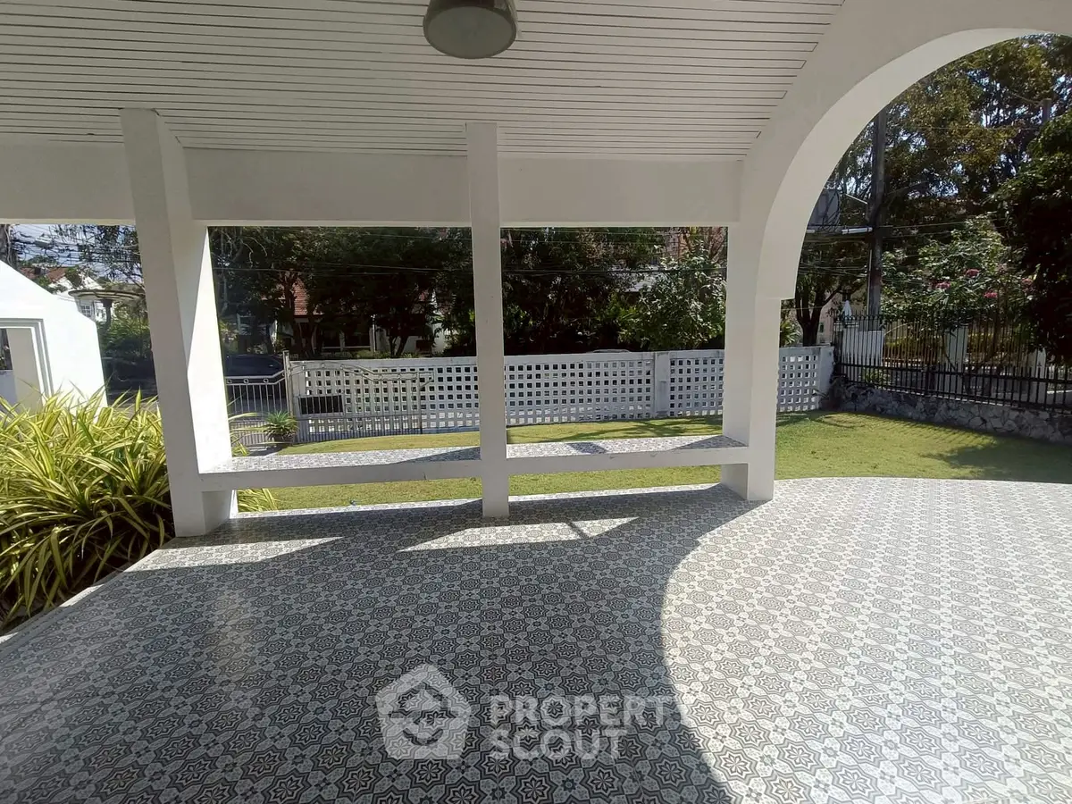 Spacious covered patio with decorative tiles and garden view