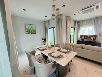 Elegant modern living room with dining area, featuring stylish furniture and natural light.