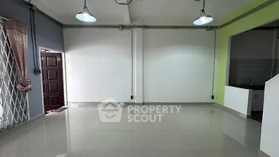 Spacious empty living room with tiled floor and open kitchen layout