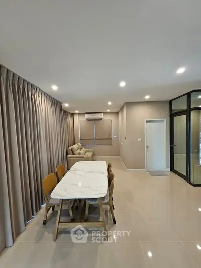 Spacious modern living room with elegant dining area and cozy sofa, perfect for entertaining guests.