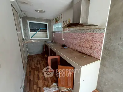 Spacious kitchen with wooden cabinets and tiled backsplash, ideal for renovation.