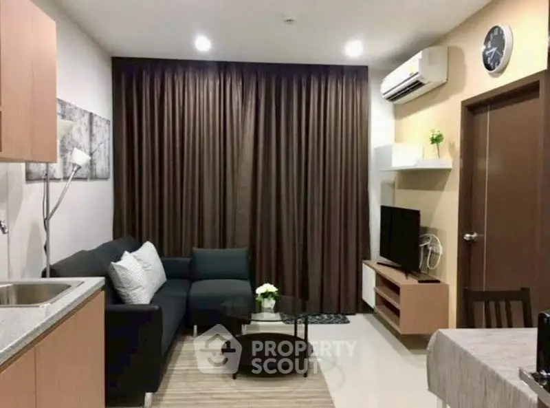 Modern living room with cozy sofa, wall-mounted TV, and stylish decor in a contemporary apartment.