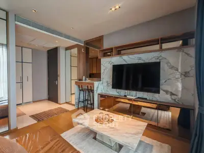 Luxurious modern living room with marble accents and large TV, perfect for relaxation and entertainment.