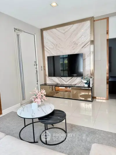Modern living room with sleek TV setup and stylish marble accents