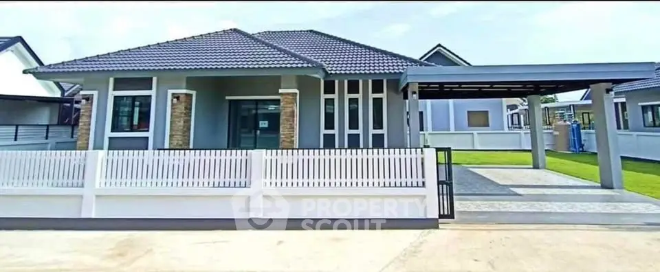 Modern single-story house with carport and stylish fence in a suburban neighborhood.