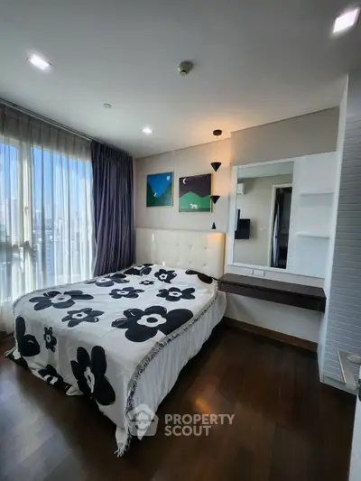 Modern bedroom with large window and stylish decor in a high-rise apartment.