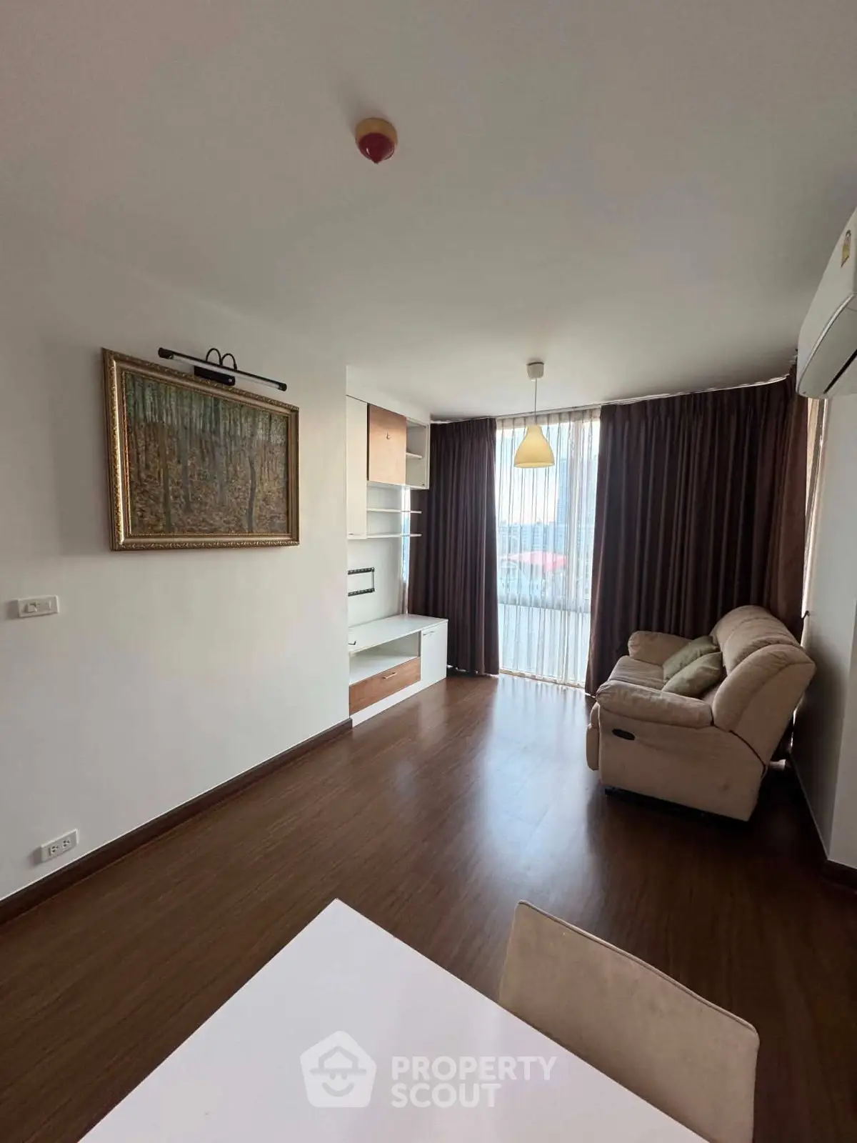 Spacious living room with modern decor and large window in a stylish apartment.