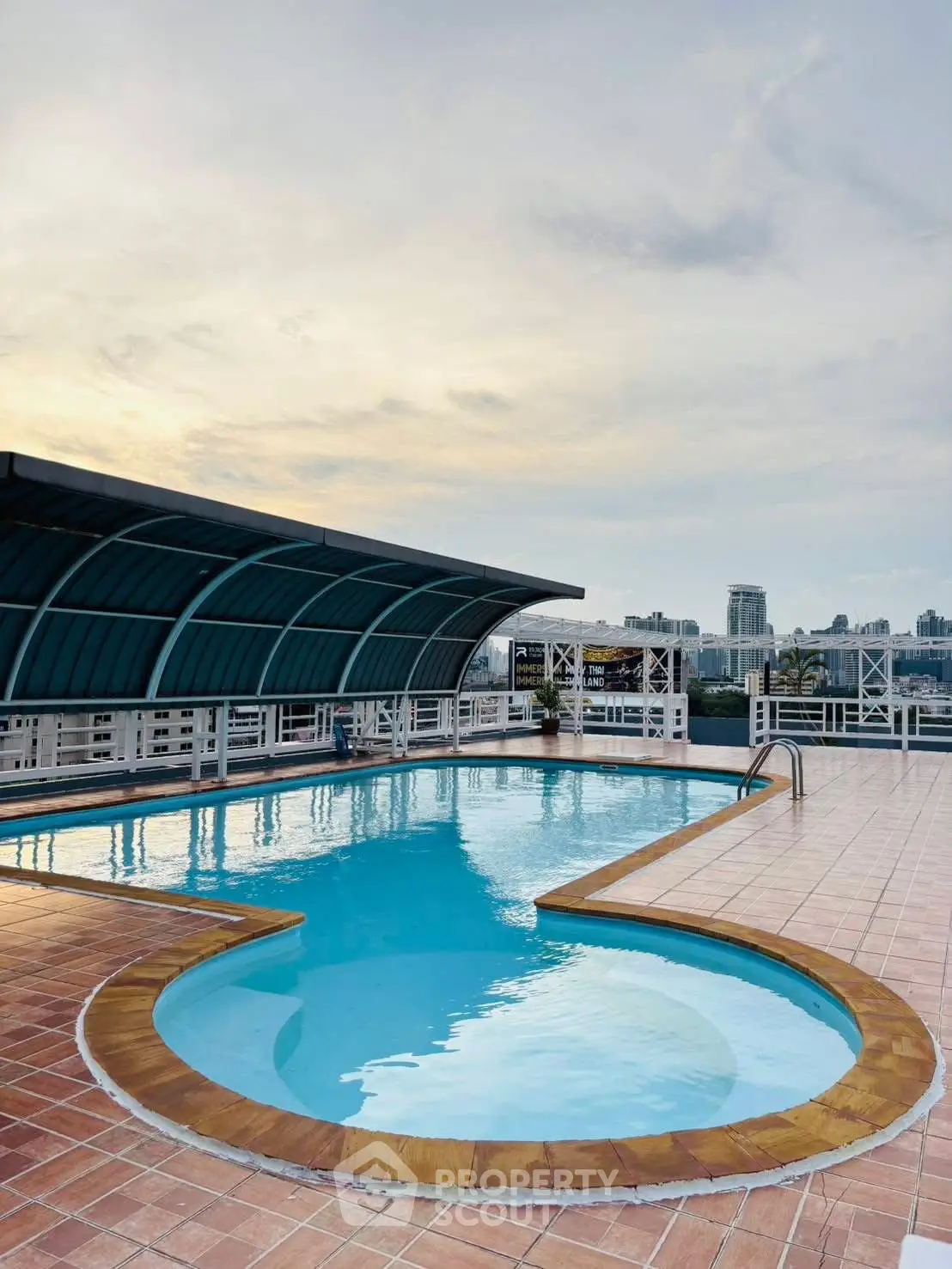 Stunning rooftop pool with panoramic city views at sunset, perfect for relaxation and leisure.