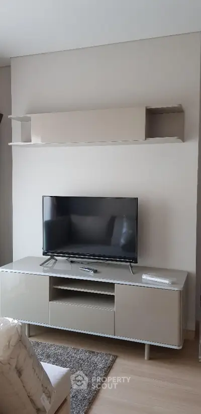 Modern living room with sleek TV stand and wall-mounted shelf