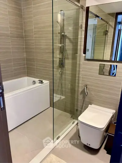 Modern bathroom with glass shower and sleek fixtures in luxury apartment.