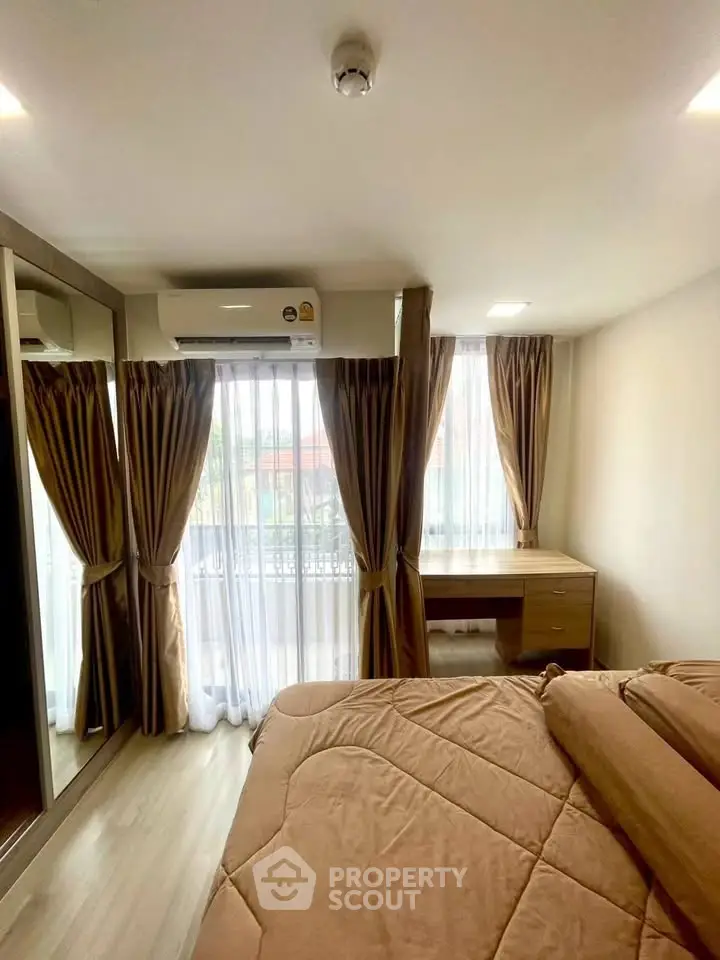 Cozy bedroom with large windows and elegant curtains, featuring a mirrored wardrobe and air conditioning.