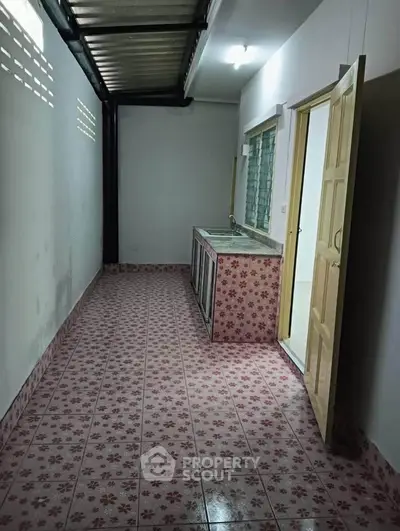 Charming narrow kitchen with floral tile flooring and open layout, perfect for cozy cooking experiences.