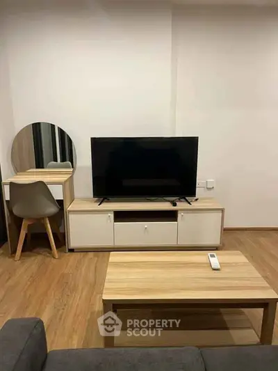 Modern living room with sleek TV stand, wooden flooring, and stylish furniture.