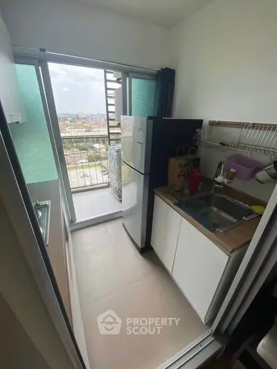 Compact kitchen with balcony view, featuring modern appliances and efficient layout.