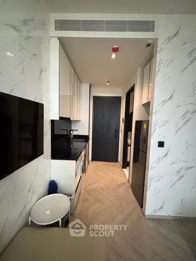 Modern kitchen with sleek cabinetry and integrated appliances in a compact layout.