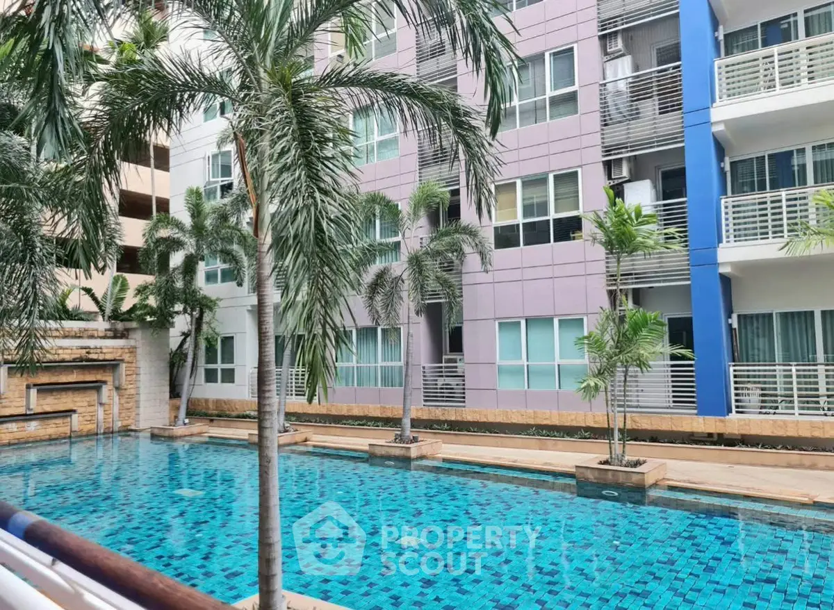 Modern apartment building with a stunning pool and palm trees, perfect for luxury living.