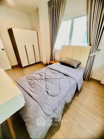 Cozy bedroom with modern decor and natural light, featuring a stylish bed and wardrobe.