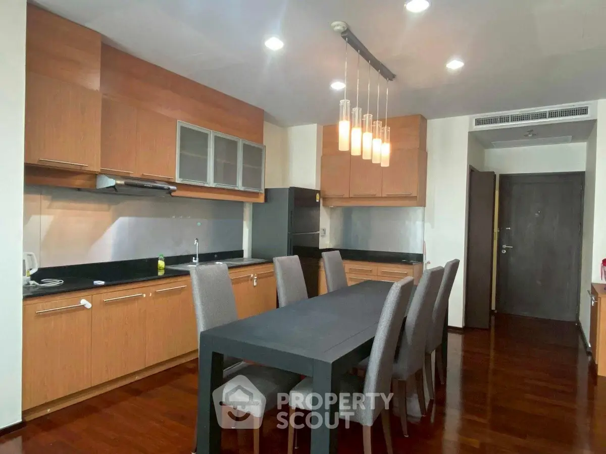 Spacious modern kitchen with sleek dining area and elegant lighting fixtures.