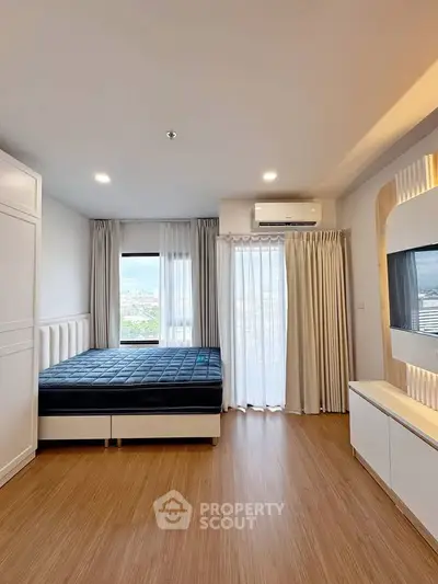 Modern bedroom with large window and city view, featuring sleek design and natural light.