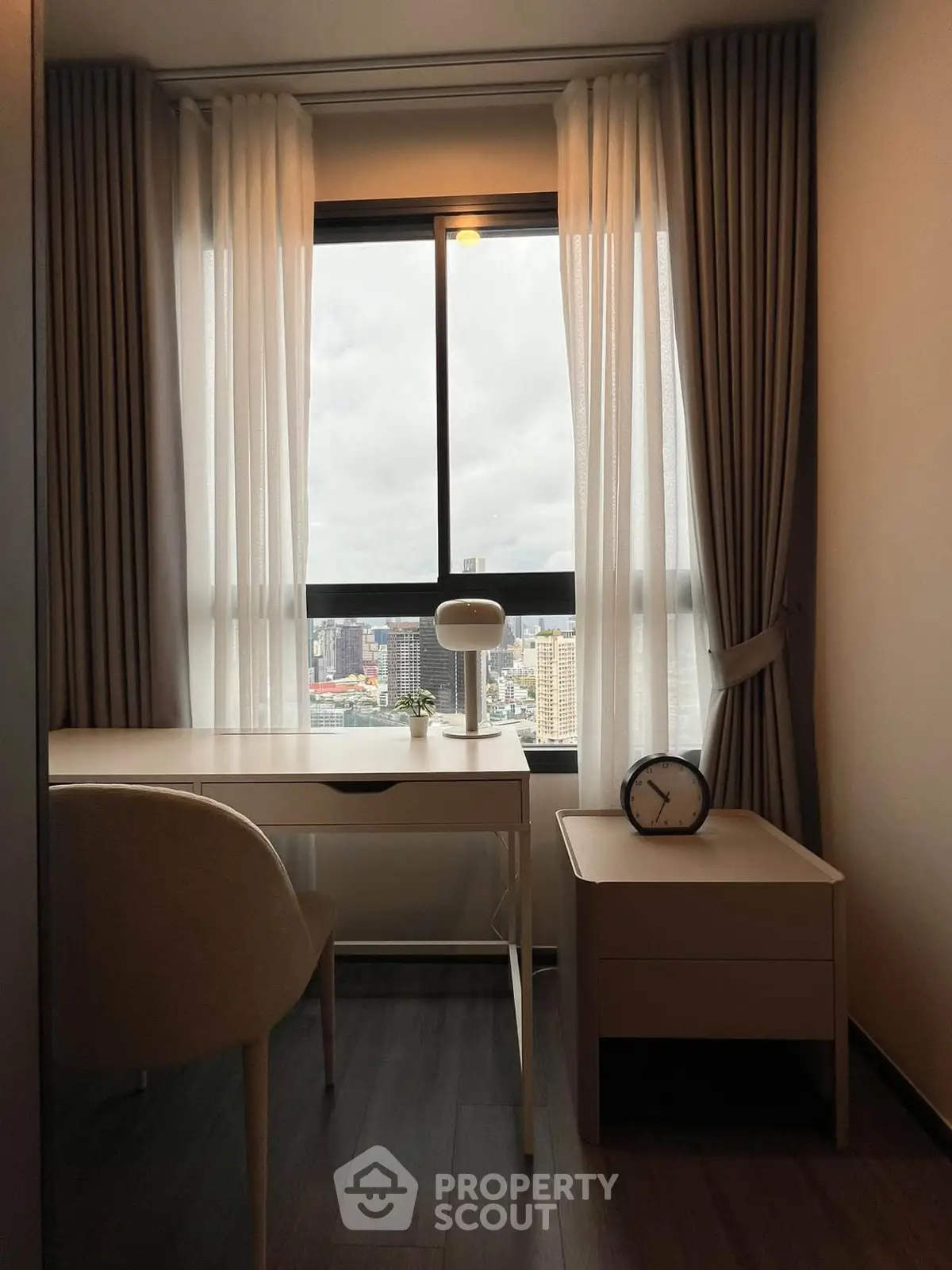 Modern study room with city view, featuring sleek desk and elegant curtains, perfect for productivity and inspiration.
