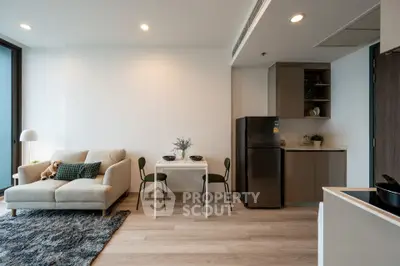 Modern open-plan living room with cozy sofa and dining area in stylish apartment.