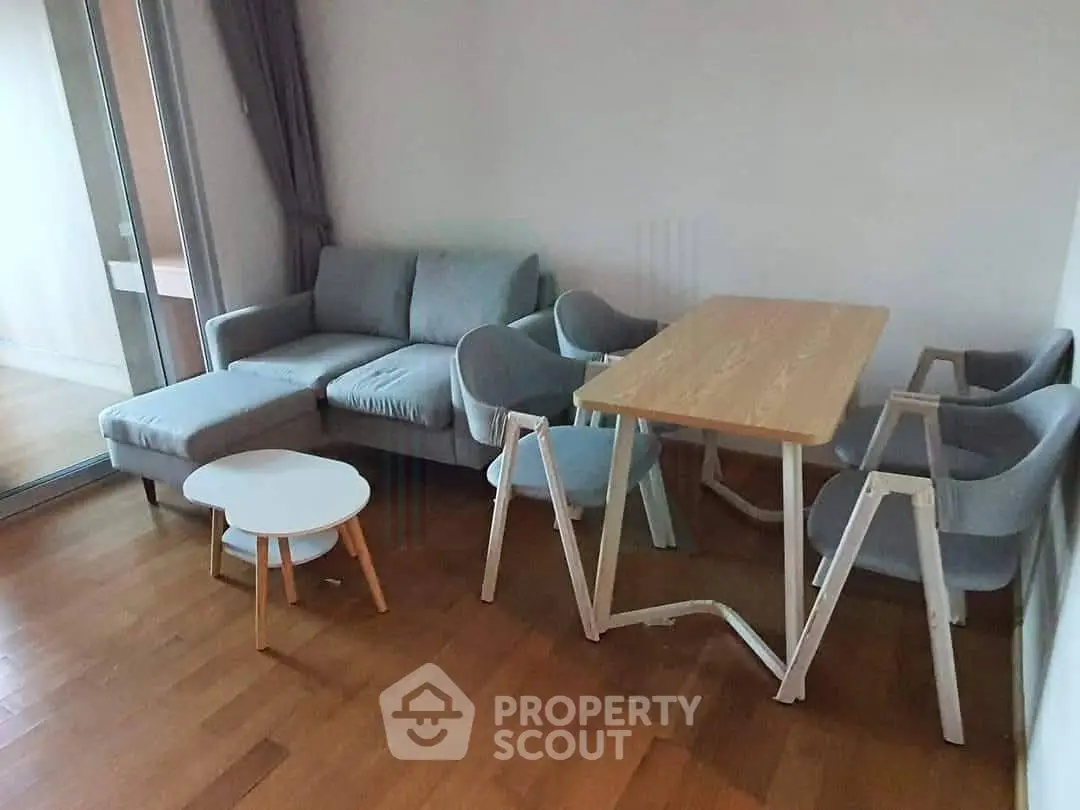 Modern living room with stylish furniture and wooden flooring, featuring a cozy sofa and dining table.