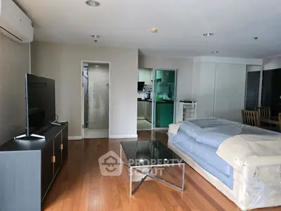 Spacious living room with modern furniture and open kitchen layout.