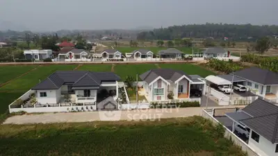 Stunning aerial view of modern suburban homes with lush green surroundings and scenic landscape.