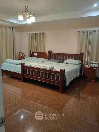 Spacious bedroom with elegant wooden bed and polished flooring
