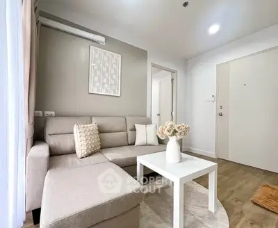 Modern living room with beige sectional sofa and white coffee table in a cozy apartment.