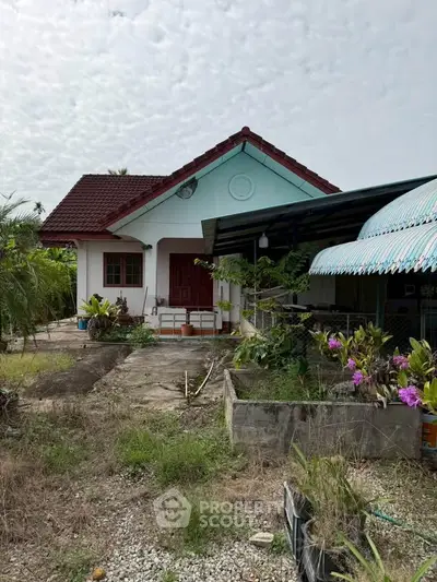 Charming single-story house with lush garden and covered carport, perfect for serene living.