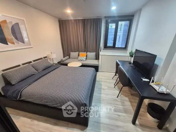 Modern bedroom with stylish decor and workspace, perfect for urban living.