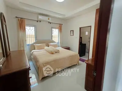 Spacious bedroom with elegant furnishings and natural light, perfect for relaxation and comfort.