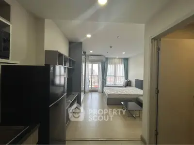 Modern studio apartment with open layout and balcony view, featuring sleek furnishings and ample natural light.