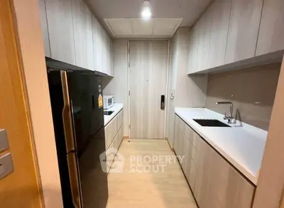 Modern kitchen with sleek cabinetry and built-in appliances in a compact layout.