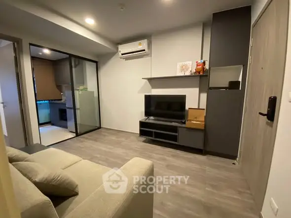 Modern living room with sleek design and open layout, featuring a cozy sofa and wall-mounted TV.