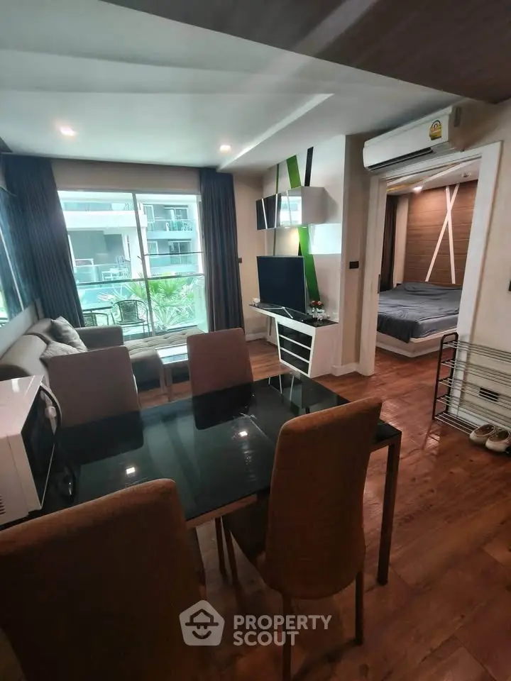 Modern living room with dining area and view of bedroom, featuring stylish decor and natural light.