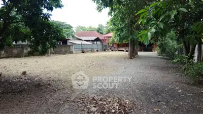 Spacious residential plot with mature trees and traditional houses, ideal for development or investment.