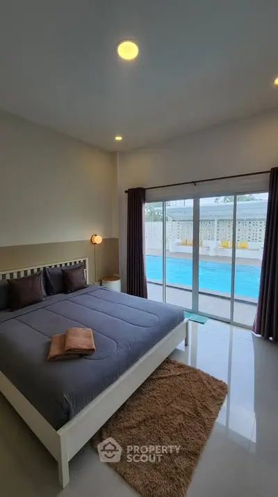 Spacious bedroom with pool view and modern decor