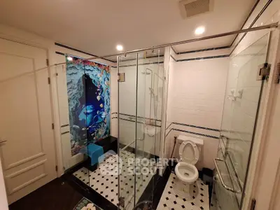 Luxurious bathroom with glass shower and artistic wall design