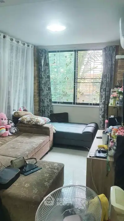 Cozy living room with large window and comfortable seating area