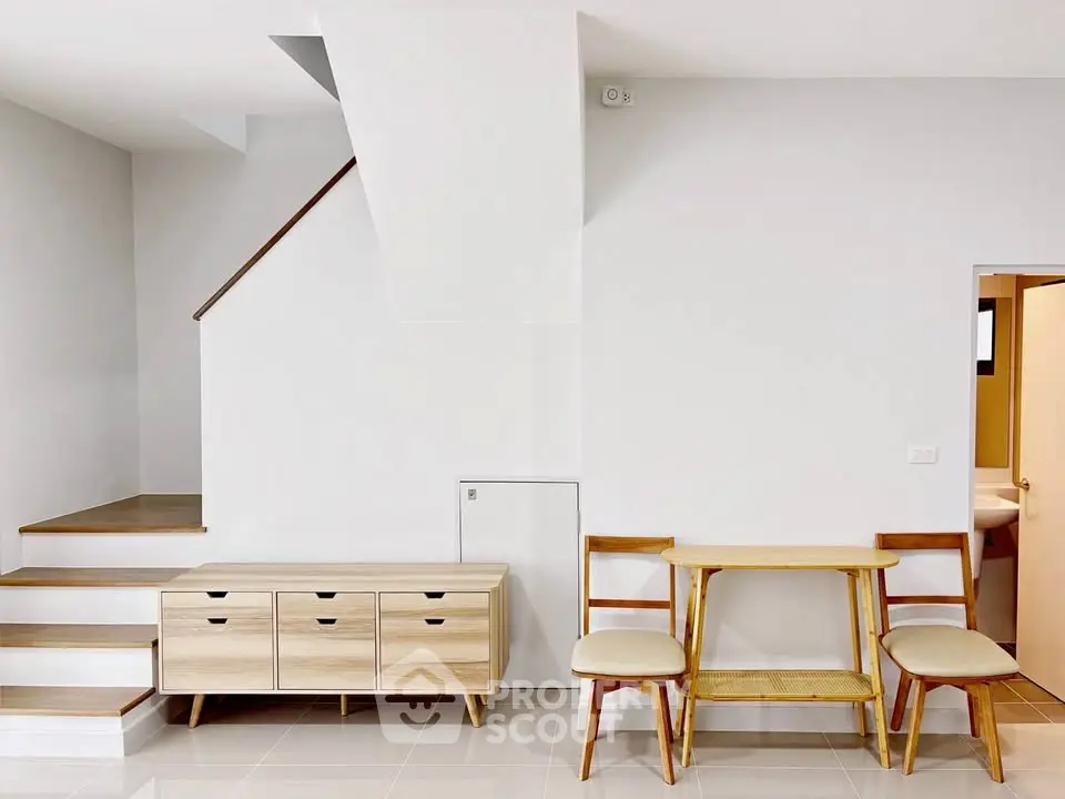 Modern minimalist interior with wooden furniture and staircase, perfect for stylish living.