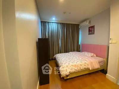 Cozy bedroom with wooden flooring and stylish decor in modern apartment.