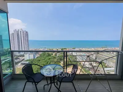 Stunning balcony view overlooking ocean and cityscape with modern high-rise buildings.