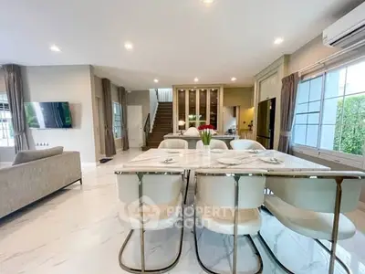 Luxurious open-plan living and dining area with modern furnishings and elegant marble flooring.