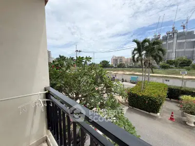 Charming balcony view with lush greenery and urban skyline, perfect for relaxation and city living.
