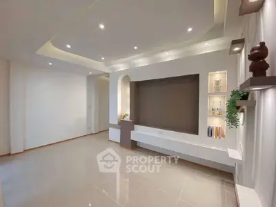 Spacious modern living room with elegant recessed lighting and decorative shelving.