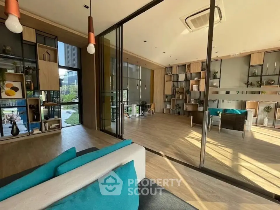 Modern living room with floor-to-ceiling windows and stylish decor, offering a bright and inviting atmosphere.